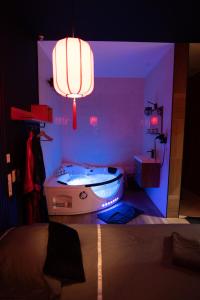 ein Schlafzimmer mit einer Badewanne in einem lila Zimmer in der Unterkunft Capsule Japon - Jacuzzi - Netflix & Ecran Cinéma - Xbox in Saint-Léger