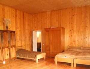 una camera con 2 letti e pareti in legno di Guesthouse Lenjeri a Mestia
