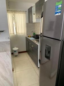 cocina con nevera de acero inoxidable en Apartamento cerca del CC Titan Plaza, en Bogotá