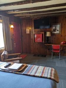 a hotel room with a bed, chair, and desk at Foot of the Mountain Motel in Boulder