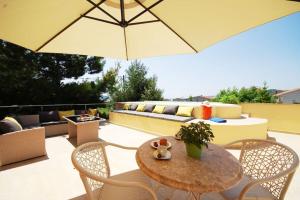a patio with a table and chairs and an umbrella at Apartmant with Pool 8 in Kaštela