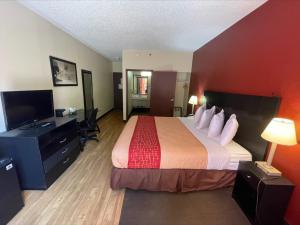 ein Hotelzimmer mit einem großen Bett und einem Schreibtisch in der Unterkunft Tropical Palms Hotel in Clearwater
