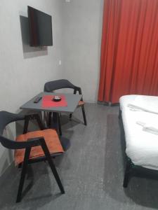 a room with a table and a chair and a tv at Hotel Ragnar in Nizhnyaya Alekseyevka