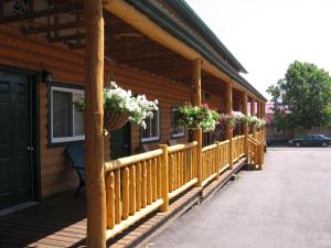 a wooden porch with potted plants on a building at Adventure Inn in Ely