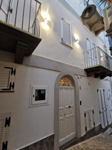 a white house with a door and a balcony at Lo Nardo Accommodation in Lipari