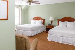 a hotel room with two beds and a couch at Admiral's Inn Resort in Ogunquit +72 photos