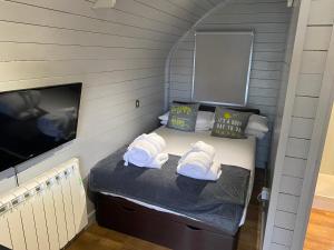 a small room with a bed and a tv at Highland Stays - Ben View Studio Pod & Jacuzzi Bath in Fort William