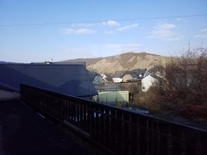 a house with a fence and a mountain in the background at Gästehaus Vinum in Leiwen