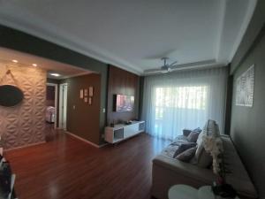 a living room with a couch and a television at Apartamento condomínio Ilha Bela - Braga in Cabo Frio