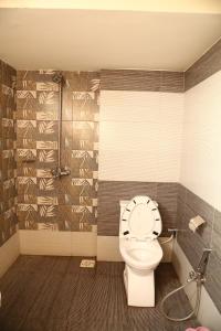 a bathroom with a toilet with a clock on the wall at Hotel Executive One in Multan