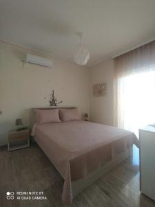 - une chambre avec un grand lit et une fenêtre dans l'établissement VILLA ALKMINI NEAR THE AIRPORT, à Vravrona