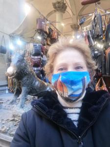 Una donna con una maschera facciale e un cane in un negozio di Tre Gigli Firenze BB, 5 minutes from station, via Palazzuolo 55 a Firenze