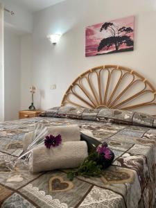 a bedroom with a bed with towels and flowers on it at Residenza A&D in Santa Domenica