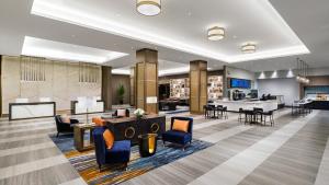 a lobby of a hotel with chairs and tables at Hyatt Regency JFK Airport at Resorts World New York in Queens