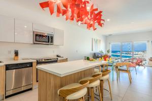 a kitchen with a large island in a kitchen with chairs at Put On Your Red Shoes And At This Condo in Madiki