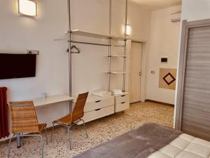 una camera da letto con una scrivania e due sedie e un letto di Il giardino di Iole Via Giovanni Amendola n36 a Sassari
