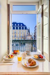 a table with plates of breakfast food and a window at Solar dos Poetas in Lisbon