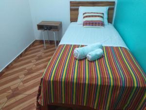 uma cama com duas almofadas num quarto em Chakana Family Home 2 Lima Airport em Lima