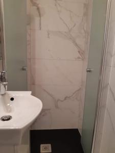 a white bathroom with a sink and a shower at Punta Nana Mira in Piran +9 photos