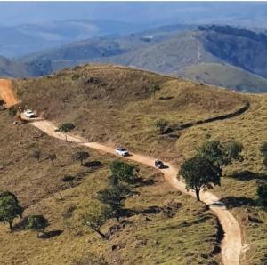 a winding road on a hill with cars on it at Pousada e Restaurante Boia Cross in Vargem Bonita