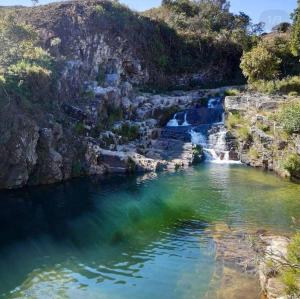 a river with a waterfall in a canyon at Pousada e Restaurante Boia Cross in Vargem Bonita