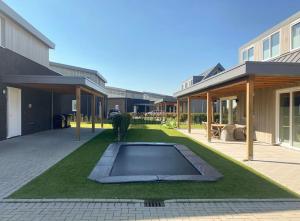 een tuin met een zwembad in het midden van een huis bij luxe Villa Maroma Regal aan Veerse meer met 4 Ebikes GasBBQ & EV laadpaal in Kamperland