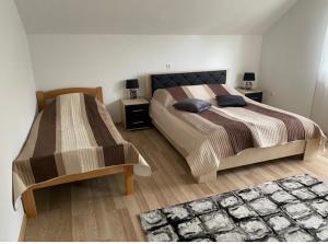 a bedroom with two beds and a rug at Amar Apartmani, Jajce in Jajce