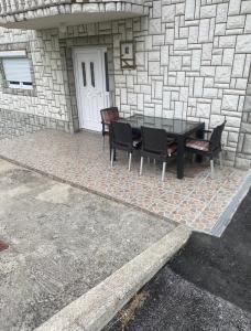 a patio with a table and chairs in front of a building at Amar Apartmani, Jajce in Jajce