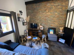 a living room with a blue couch and a brick wall at LE CHALET DES MERVEILLES in Les Achards