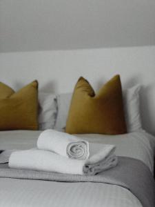 a bed with white towels and pillows on it at The Balnoon Inn with rooms in St Ives