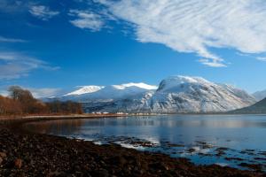 a view of snow covered mountains and a lake at Thistle Do Fort William in Fort William