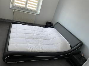 a bed in a room with a white mattress at Appartement saisonnier in Bussang