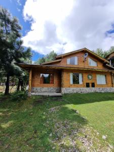 a log house with a yard at Las Cuatro Lunas in Villa Meliquina