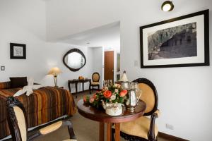 a bedroom with a bed and a table with flowers on it at Club Hotel Centro de Convenciones Cusco in Cusco