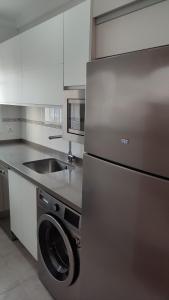 La cuisine est équipée d'un réfrigérateur en acier inoxydable et d'un évier. dans l'établissement Apartamento Paseo Marítimo, Centro Torre del Mar, à Torre del Mar