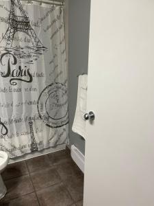 a bathroom with a shower curtain with the eiffel tower at Motel Valois YL inc in Acton Vale +11 photos