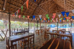 a restaurant with wooden tables and chairs and flags at Hospedaje Wotoch Aayin in Venecia