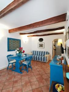 a living room with a blue table and chairs at Alguerhome Casa Turchese old town in Alghero