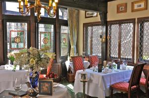 a dining room with white tables and chairs and windows at Burghotel auf Schönburg in Oberwesel
