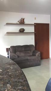 ein Wohnzimmer mit einem Sofa und einem Tisch in der Unterkunft Flat ao lado do Shopping in Santa Cruz do Sul