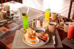 a table with a plate of breakfast foods and drinks at El Ben Cabañas in Caye Caulker