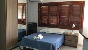 a bedroom with a blue bed and a mirror at Flat ao lado do Shopping in Santa Cruz do Sul