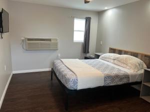 a bedroom with a bed and a window and a fan at Nightshade Inn & Gardens in Camillus