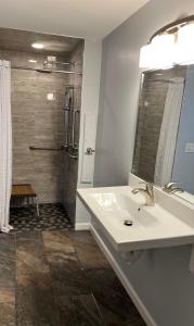 a white bathroom with a sink and a shower at Nightshade Inn & Gardens in Camillus