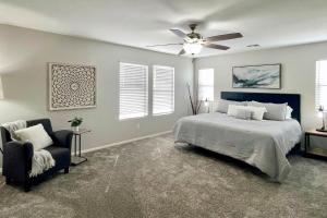 a bedroom with a bed and a ceiling fan and a chair at Game Room and Pool Spacious Queen Creek Home! in Queen Creek +29 photos