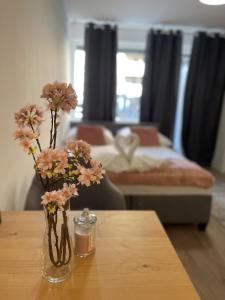 two vases with flowers on a table in a living room at Central Cosy Apartment in Cologne in Cologne