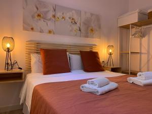 a bedroom with a large bed with towels on it at BEACH FRONT ATICO WIFI in Tarifa +36 photos