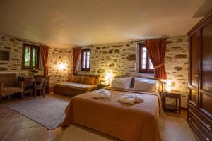 1 dormitorio con 1 cama con 2 toallas en Anovolios Boutique Hotel, en Agios Georgios Nilias