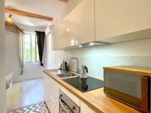 uma cozinha com um lavatório e uma bancada em LaFrenchCasa Noailles em Marselha