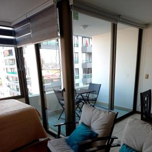 um quarto com uma cama e uma varanda com uma mesa em DEPARTAMENTO EDIFICIO AZUL I em Iquique